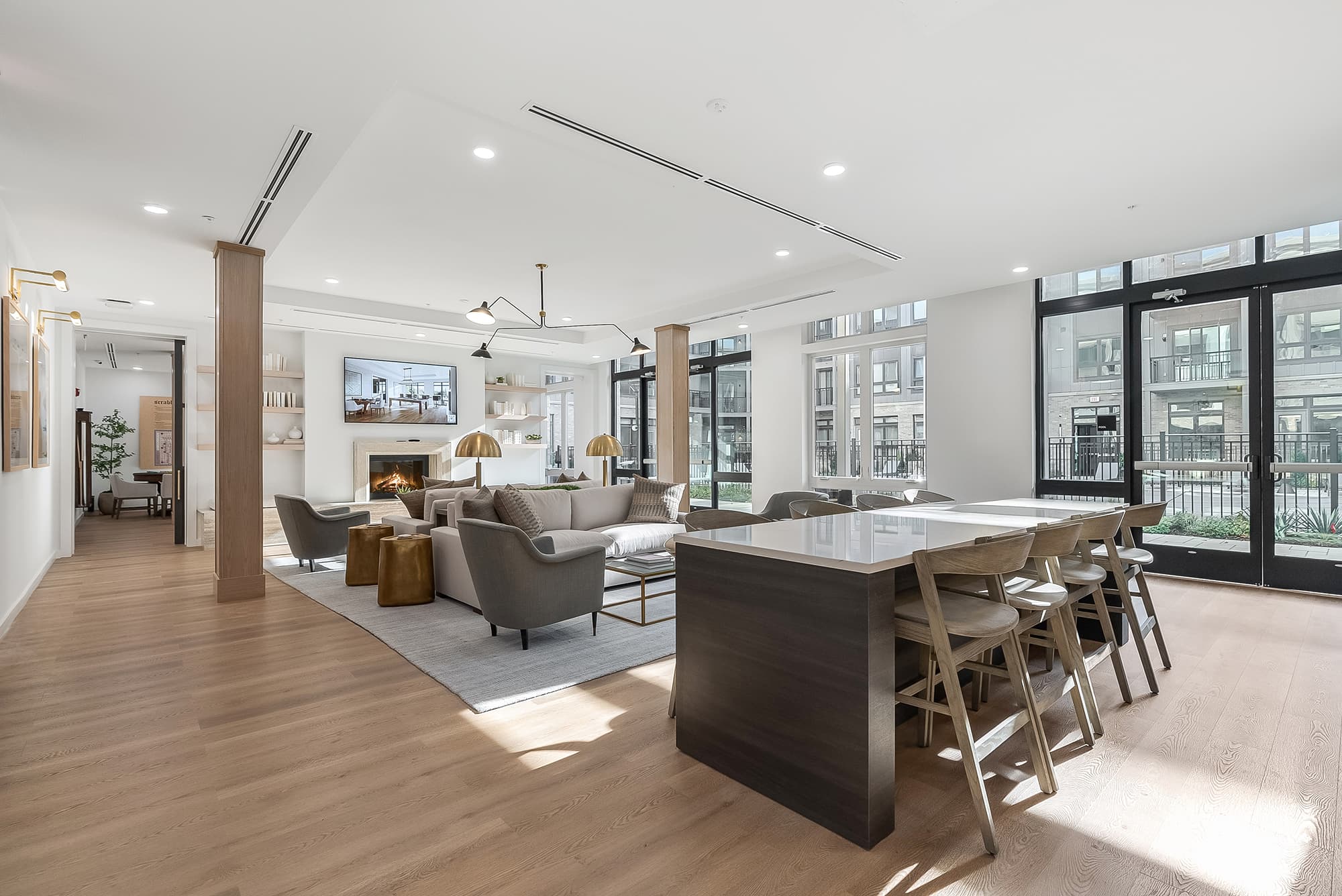 Spacious resident clubhouse featuring lounge sofas, fireplace, and communal kitchen island in Fair Lawn, NJ.