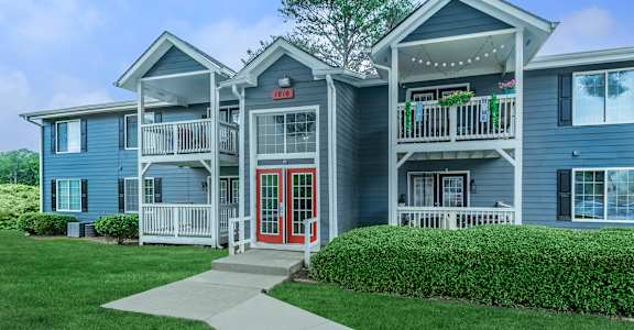 A blue building with a red door and a sign that says at Crest at East Cobb Apartments, Marietta, GA, 30062