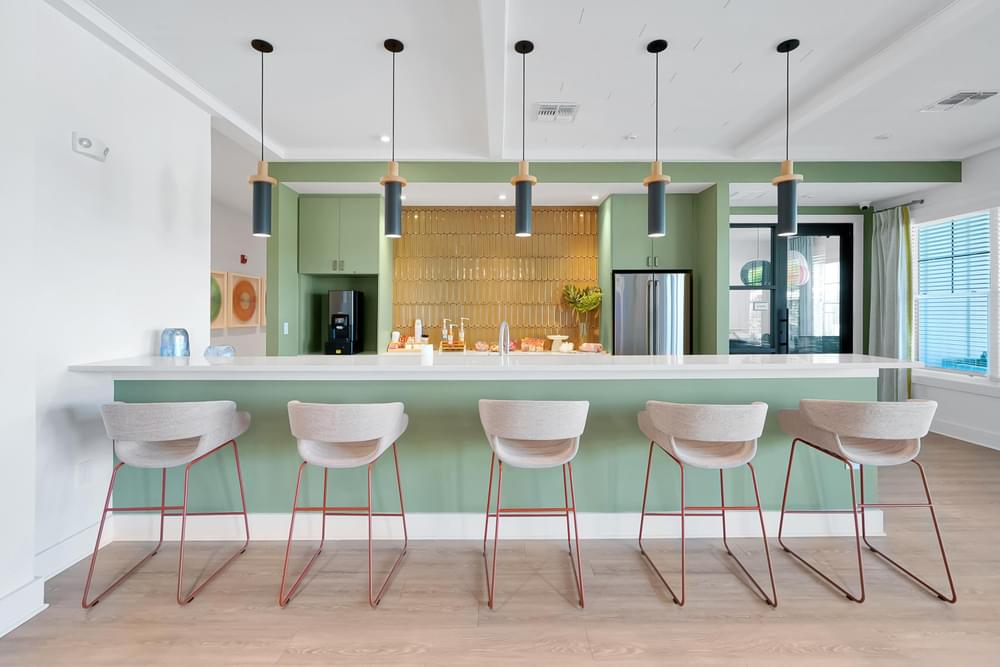 A kitchen with a bar area and four chairs.