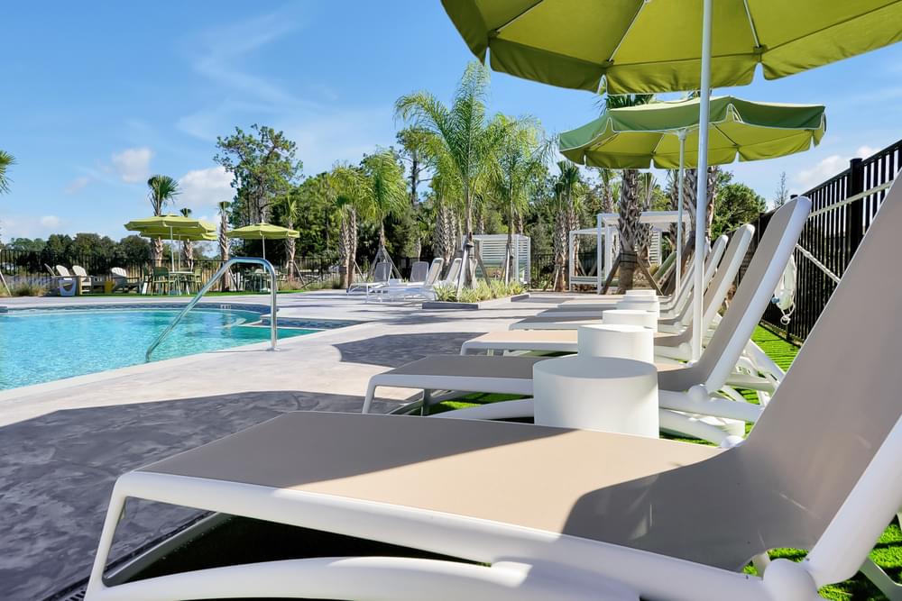 A poolside area with sun loungers and umbrellas.
