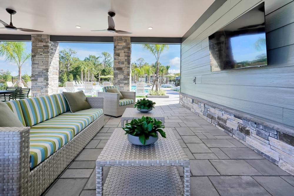 A patio with a couch, table, and potted plant.