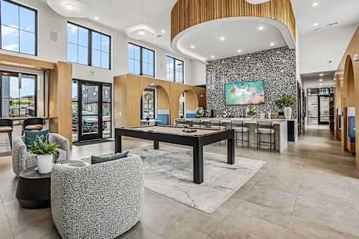 A spacious lobby with a reception desk and a large painting on the wall.