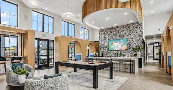 A spacious lobby with a reception desk and a large painting on the wall.