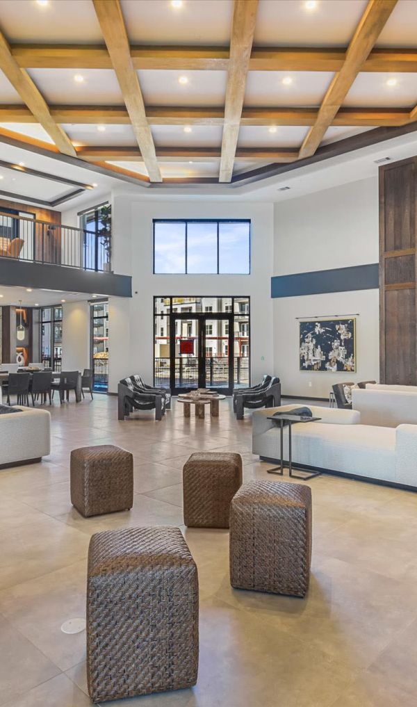 A spacious living room or lobby with modern furniture and a high ceiling at The Palo in Fort Worth, Texas