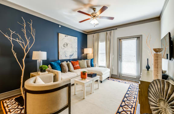 A living room with a white couch, a brown armchair, and a white coffee table.