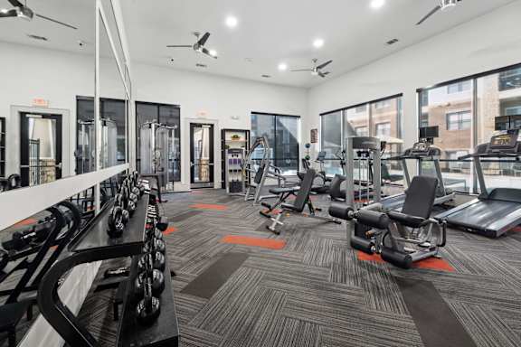 A gym with treadmills, weights, and exercise equipment.