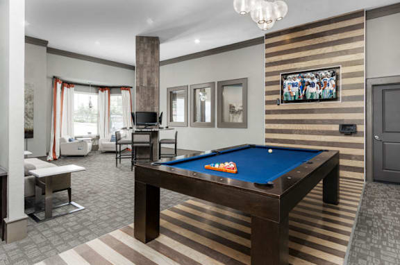 A billiard table in a room with striped walls.