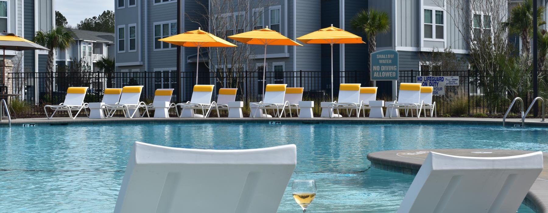 a pool with chairs and umbrellas