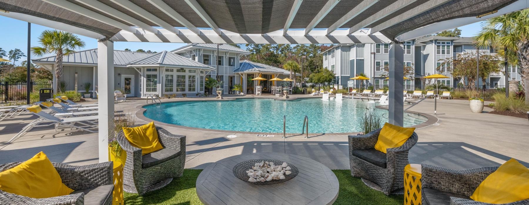 a pool with lounge chairs and a covered patio with a covered patio