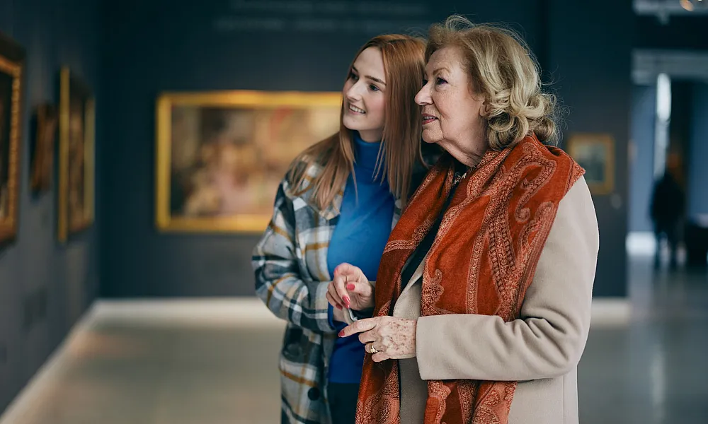 grandmother and granddaughter viewing art in a gallery