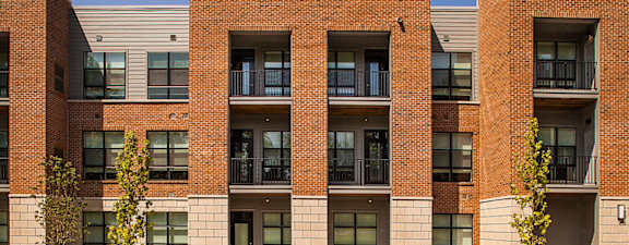 A red brick building with balconies and windows.