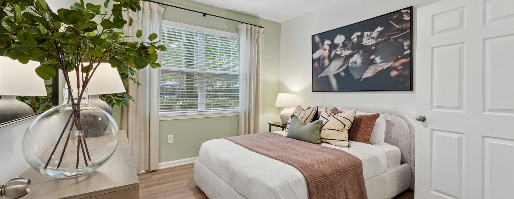 Bedroom with a window, large bed and dresser