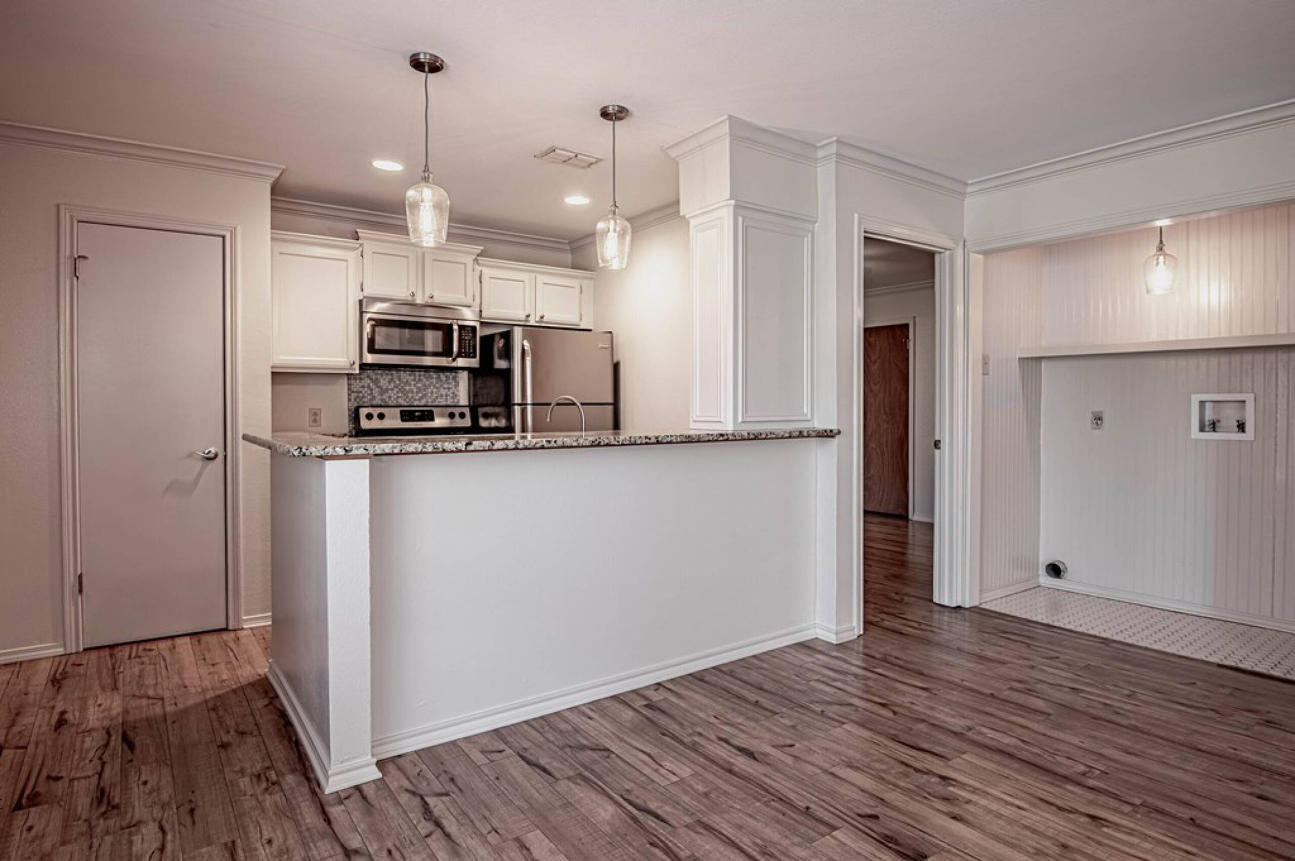 Modern kitchen with granite countertops and all-electric appliances in a Dogwood Village apartment Nacogdoches TX