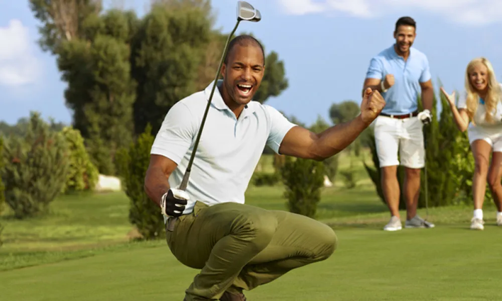 man with golf club on green