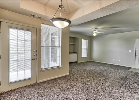 A living room with a ceiling fan and window in Arlington, TX.