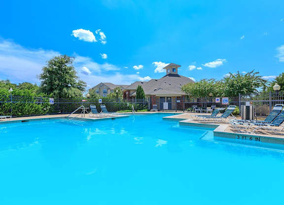 A large swimming pool with a depth of 3 feet 6 inches at Addison Park Apartments in Arlington, TX.