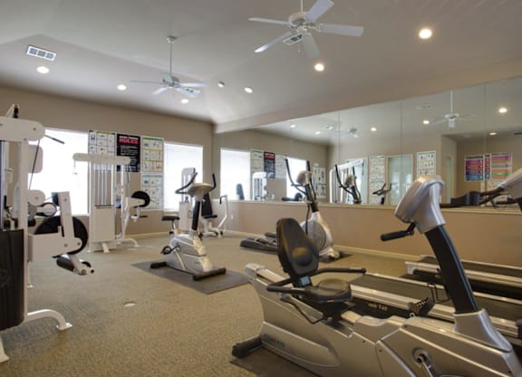 a gym with treadmills and other exercise equipment at Addison Park Apartments in Arlington, TX.