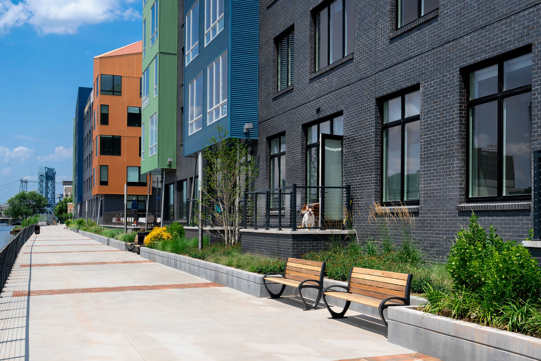 street level exterior view of modern apartments along waterfront walkway