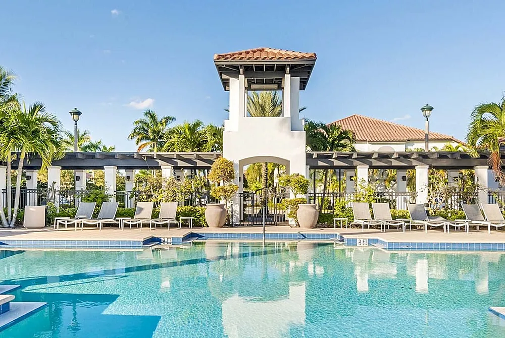 Luxurious poolside oasis with sparkling waters, elegant loungers, and lush palm trees under a pristine blue sky.