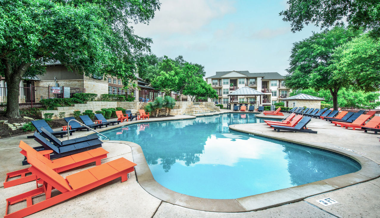 Pool with trees all around, lots of deck seating