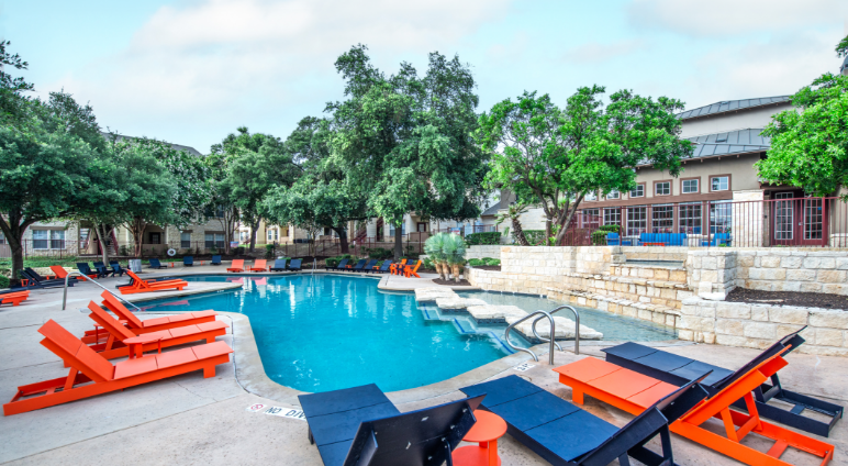 Pool with deck seating and lots of trees