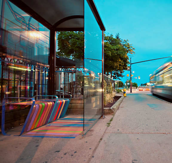 A bus is in motion on a city street at dusk.
