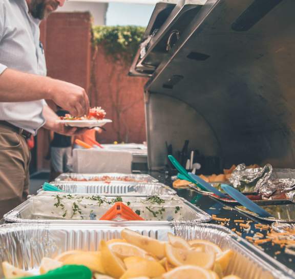 A man is preparing food on a tray with lemon slices.