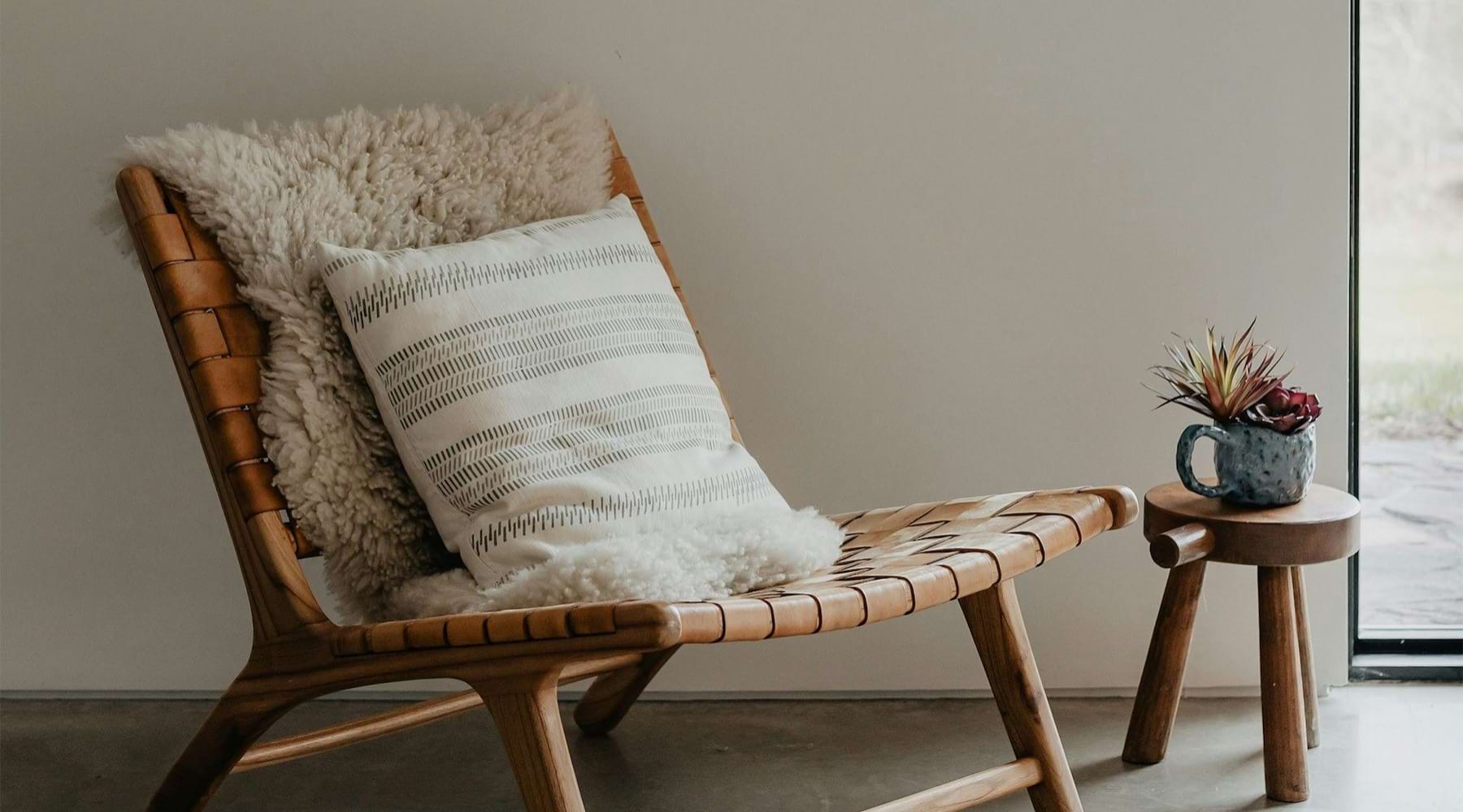 a chair in a room with a small cup on a small stool
