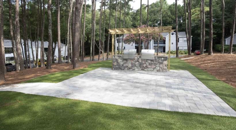 a stone patio with a grill area