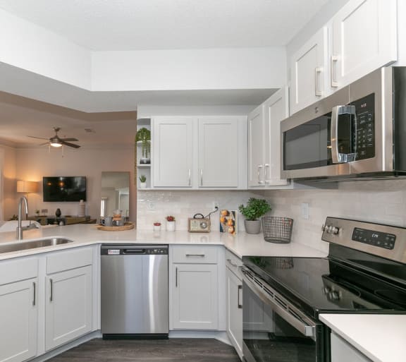 a kitchen with white cabinets and stainless steel appliances at Deerfield Village, Georgia