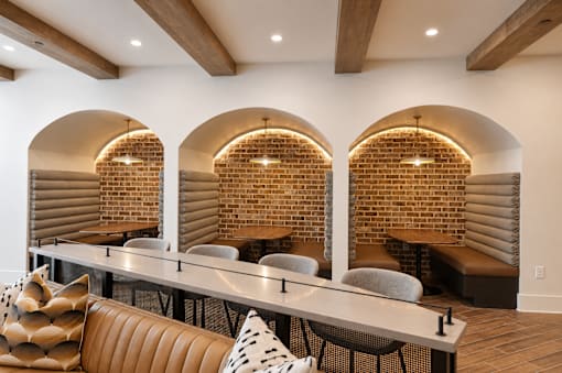 A modern living room with a brick wall and a long bench.