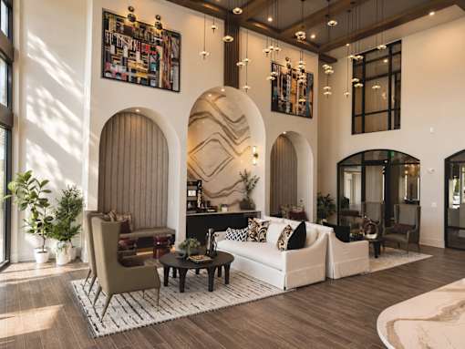 A living room with a white couch, a brown chair, and a coffee table.