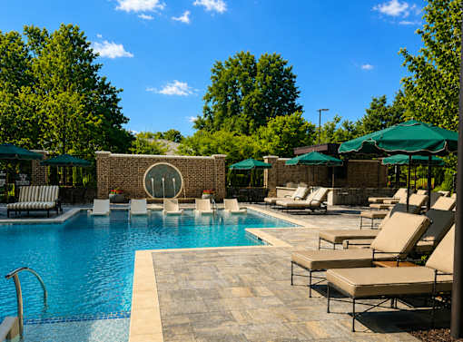 A pool area with sun loungers and umbrellas.