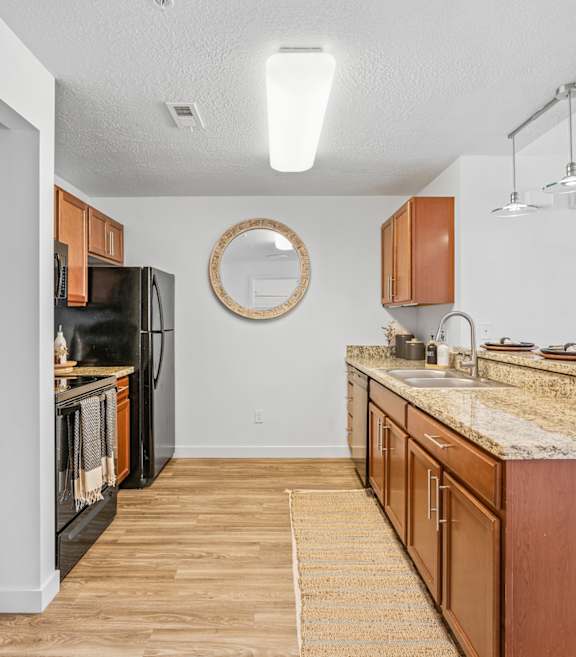 Kitchen with granite countertops and black appliances at The View on 20th, Ogden, UT, 84401