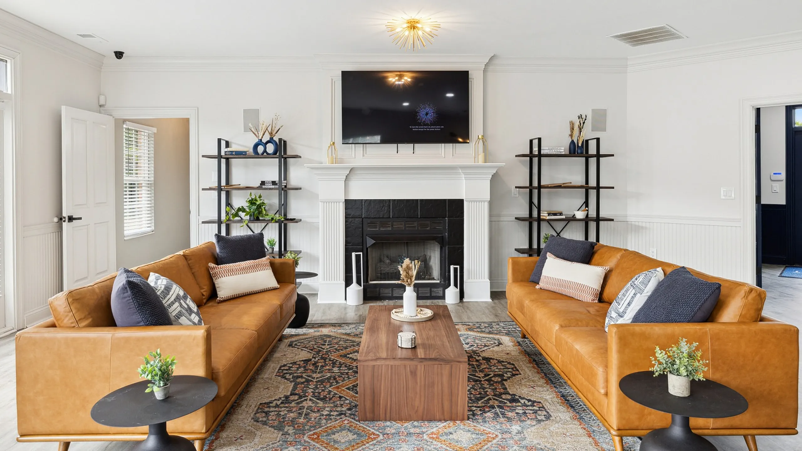 Inviting modern living room showcasing elegant leather sofas, a chic fireplace, and vibrant decor in a cozy atmosphere.