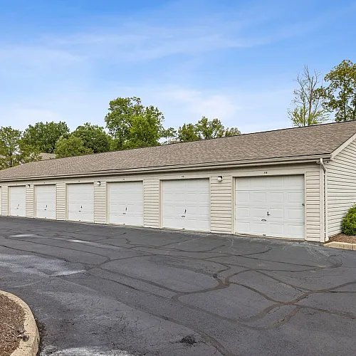 Well-maintained residential parking area with multiple garage units and lush greenery, offering secure and convenient vehicle storage.