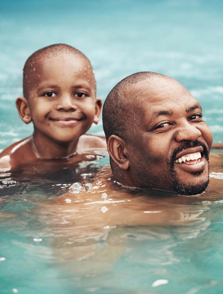 Shot of a happy little boy having fun with his father in a swimming pool