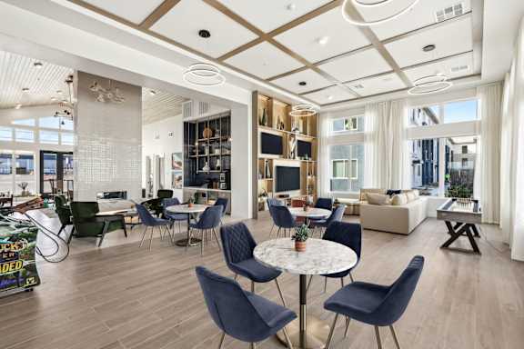 A modern living room with a dining area and a kitchen in the background.