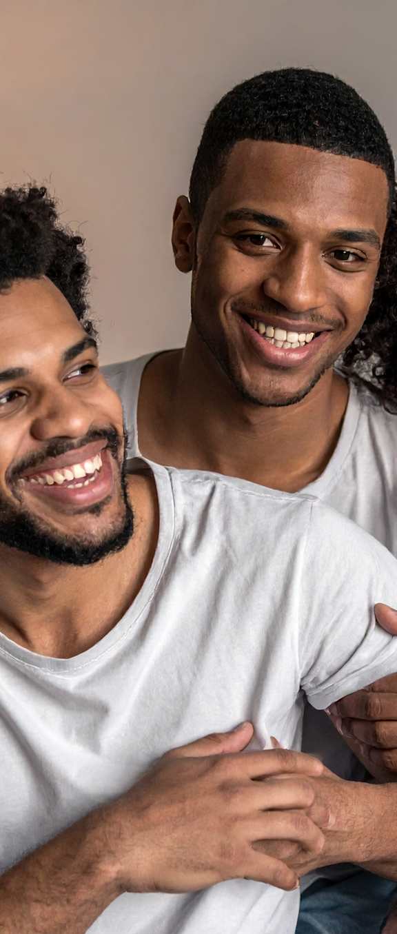 Three people hugging each other in a living room.