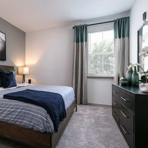 an open concept living room and dining area with a white dining table and rattan chairs at Enclave at 3230 Apartments, South Daytona, 32119