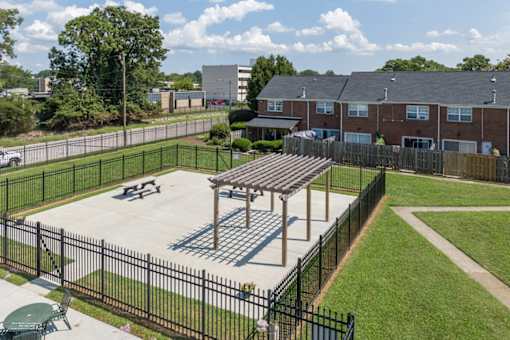 A black fence surrounds a playground with a wooden structure.