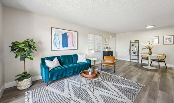 A living room with a blue couch and a grey rug.