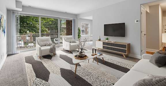 a living room with white furniture and a flat screen tv on the wall at Padonia Village Apartments, Timonium, MD