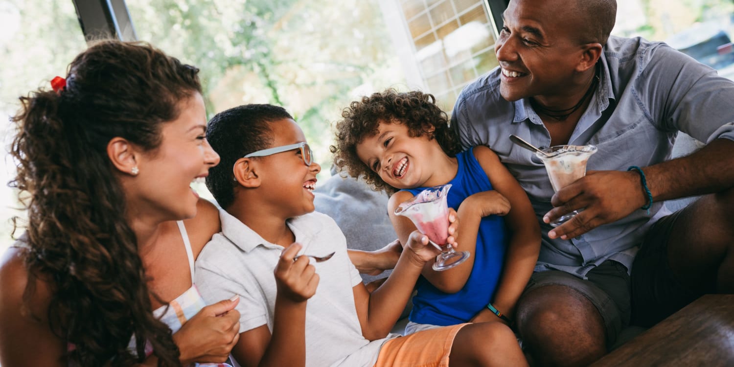 Residents and their kids sitting on their couch at home at The Residences at Renaissance in Charlotte, North Carolina