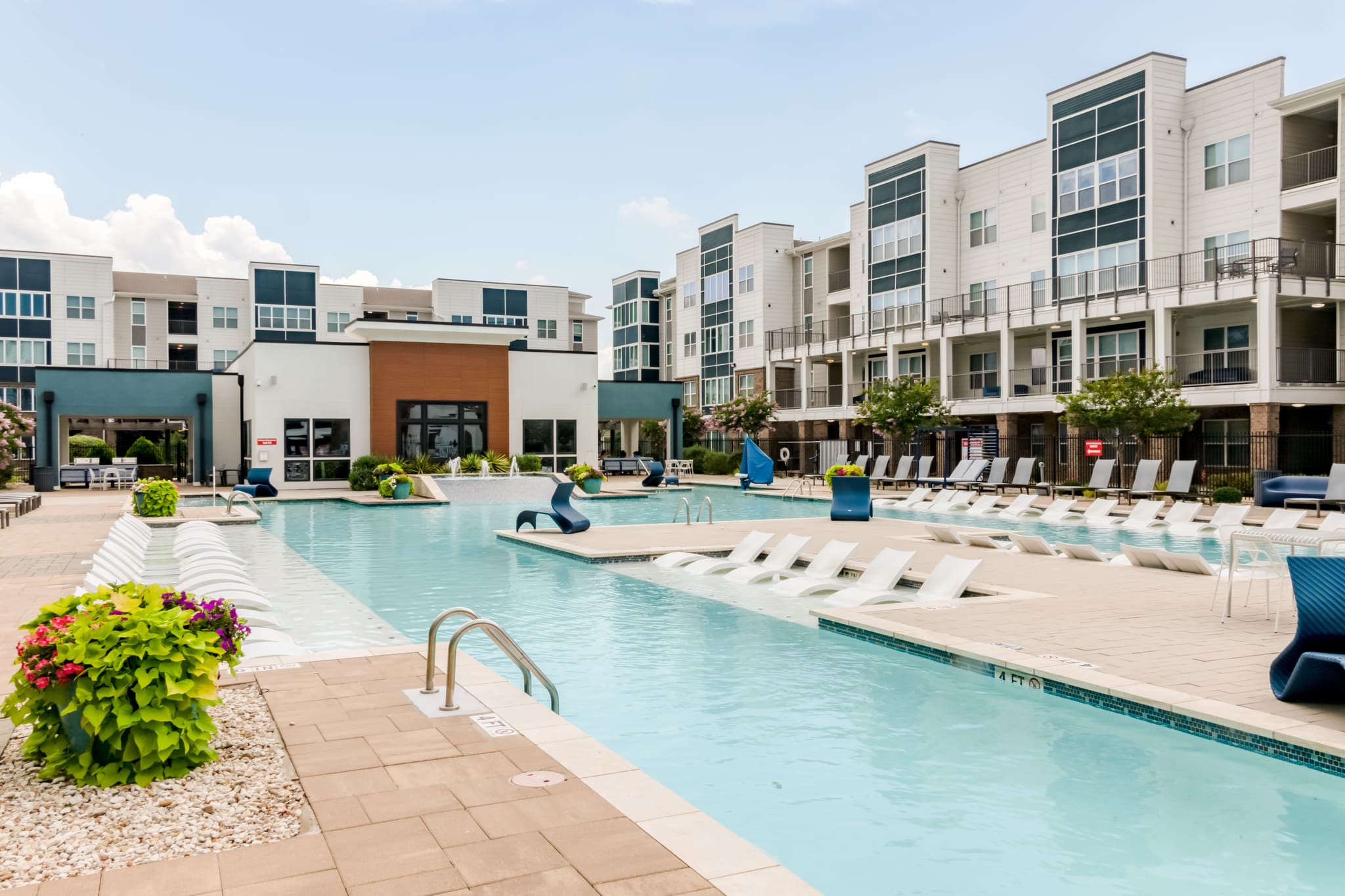 swimming pool with lounge chairs and plants