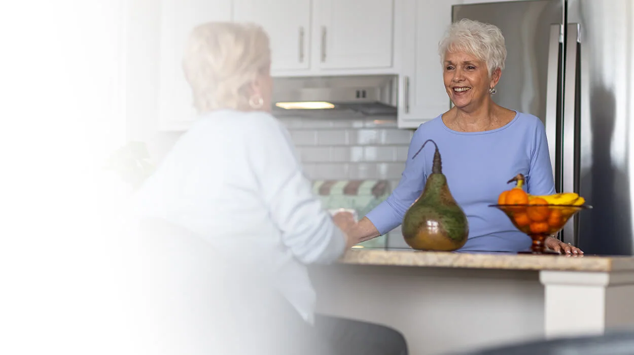 two women talking in kitchen