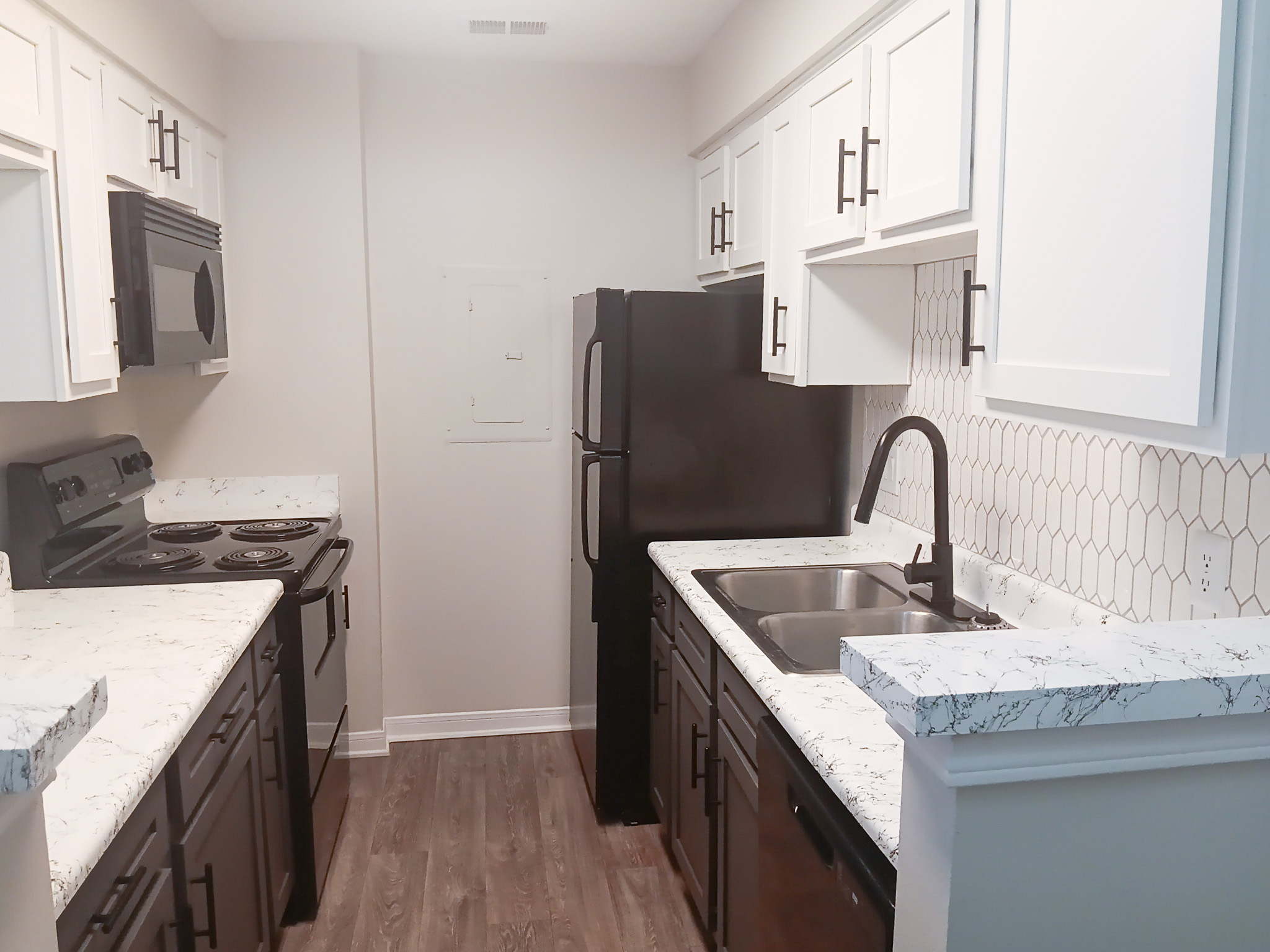 Modern kitchen with black appliances inside an apartment at The Woodlands