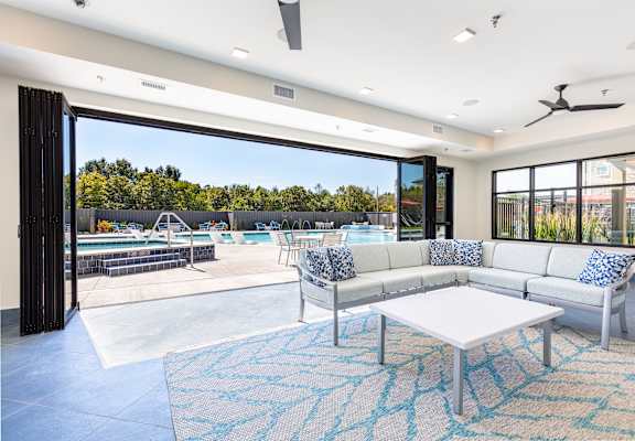 A modern living room with a pool in the backyard. at Trinity Woods Apartments, Independence, 64015