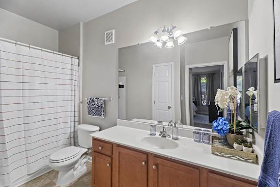 A bathroom with a toilet, sink, and shower.