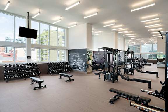 A gym with a variety of equipment including weights and benches.